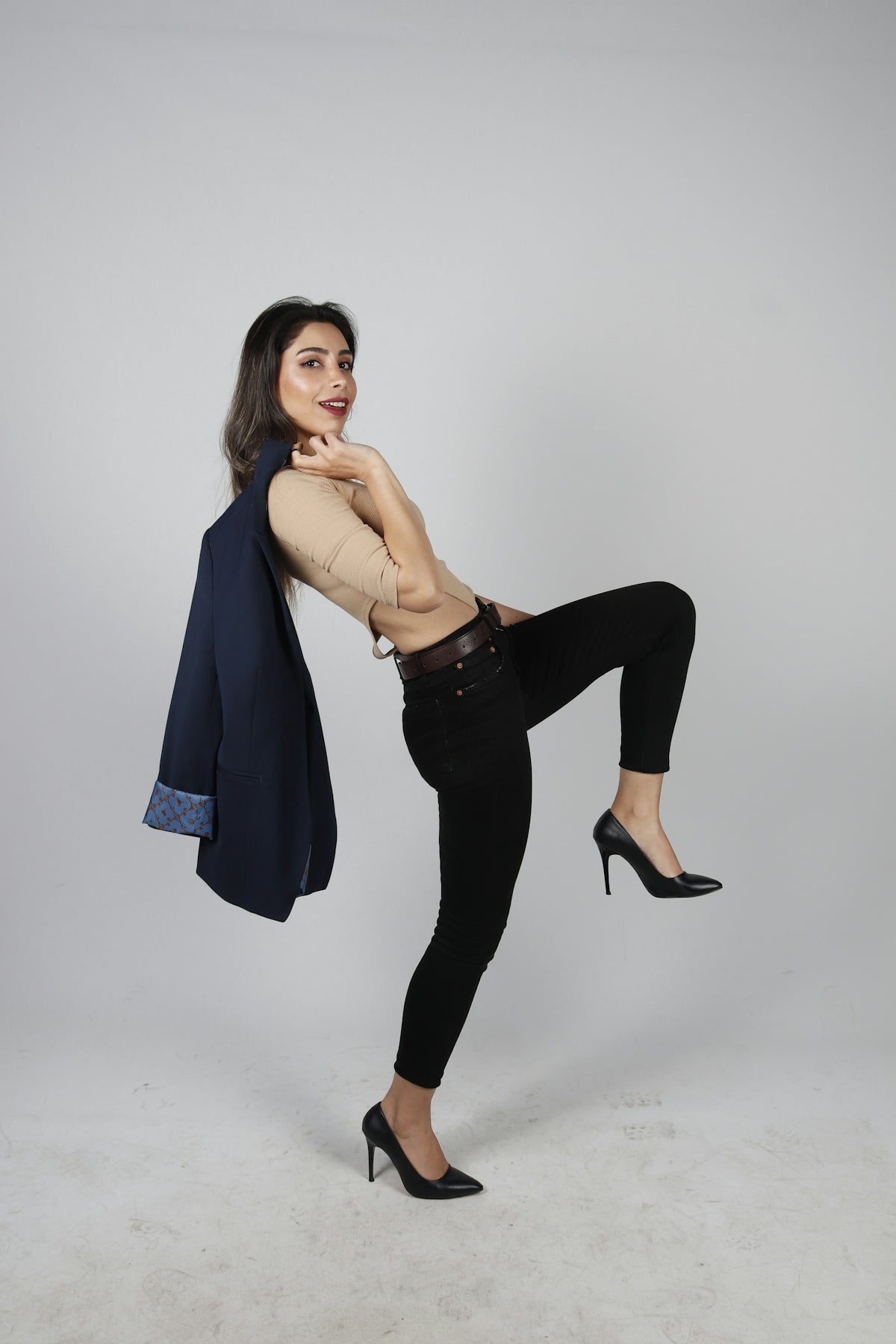a woman in black pants and heels posing for a picture